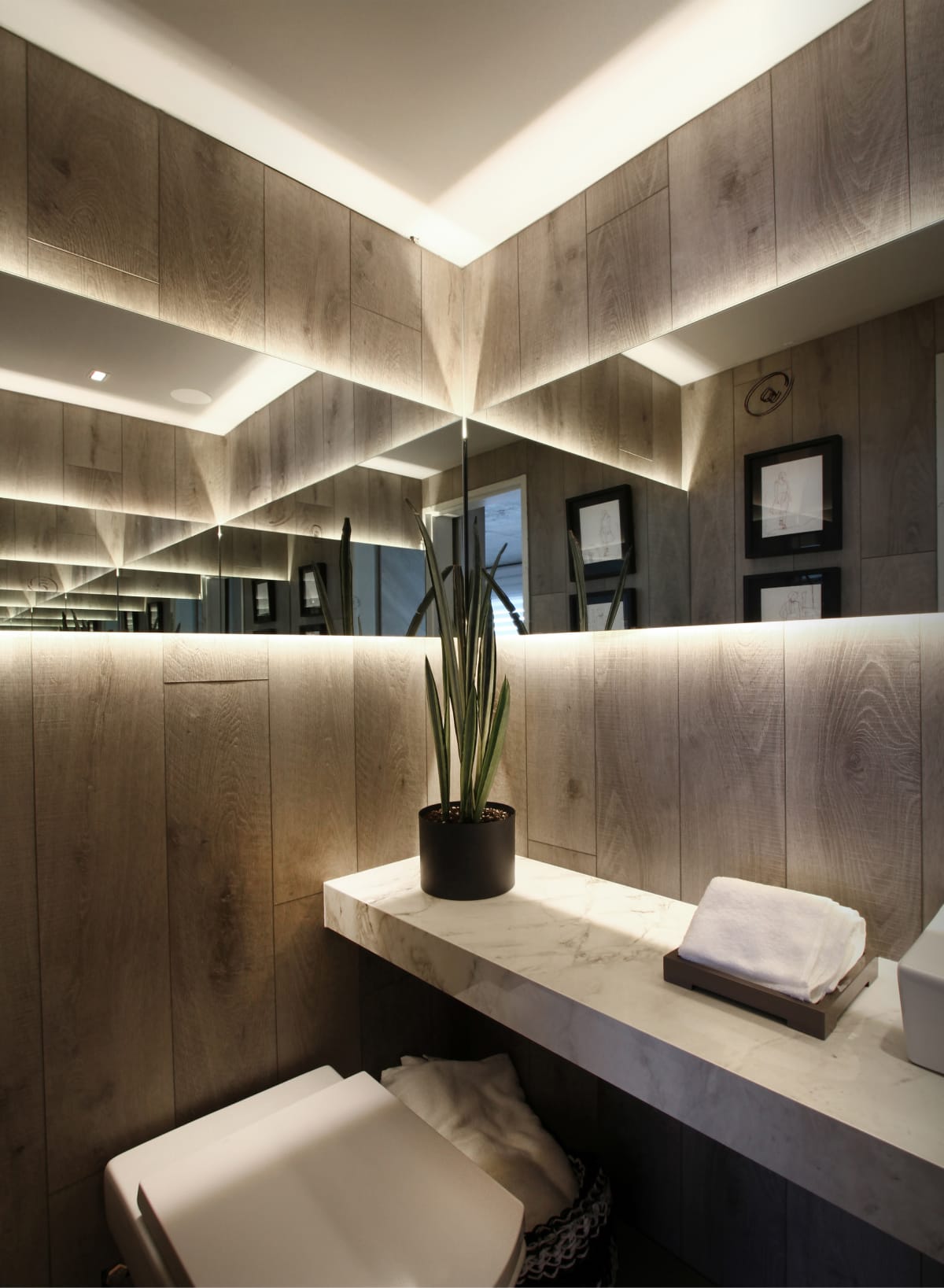 Los espejos en esquina e iluminación para crear un efecto escenográfico en el toilette.